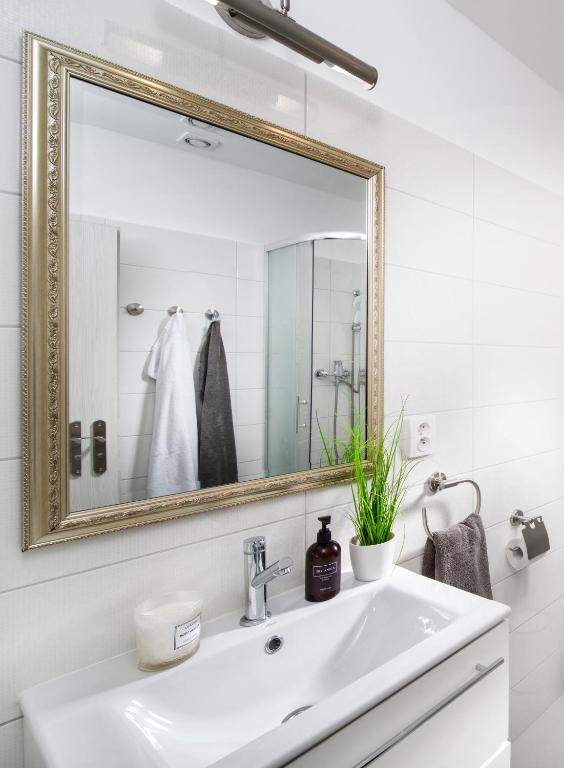 a white bathroom with a sink and a mirror at Apartmán U Pramene in Františkovy Lázně