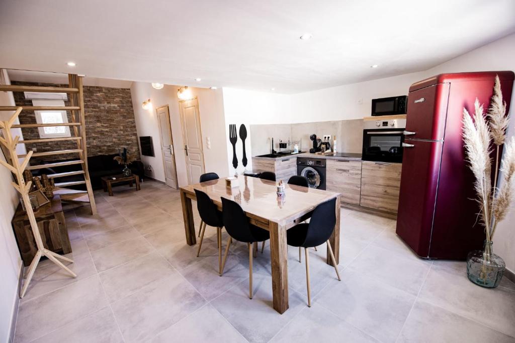 a kitchen with a wooden table and a red refrigerator at Entre Terre et Mer in Marsillargues