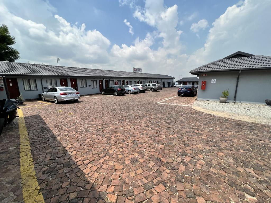 a group of buildings with cars parked in a parking lot at Ecomotel Germiston in Germiston
