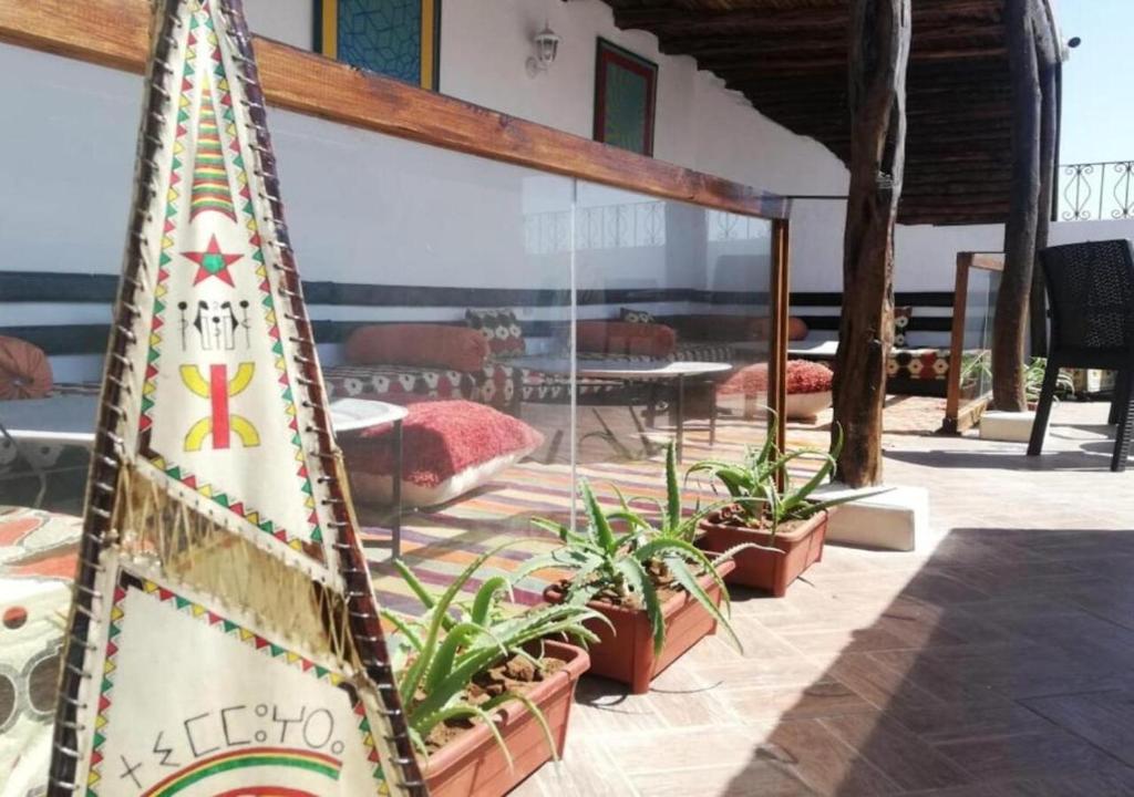 a surfboard standing next to plants in a patio at Appart, Hotel & Café Agadir in Essaouira