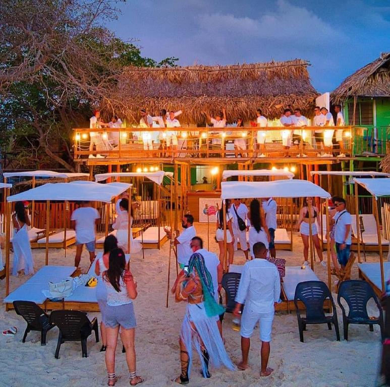 a group of people standing on the beach at a restaurant at SUNSET BEACH in Playa Blanca