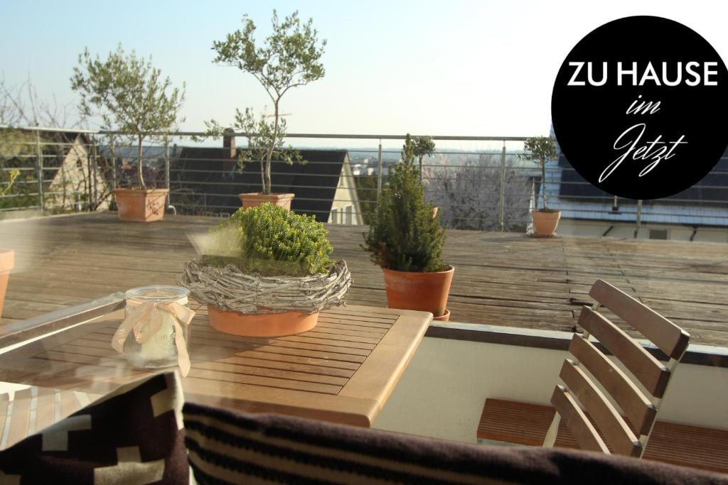 una mesa y sillas en una terraza con plantas en zuHause mit Berg-und BodenSeesicht, en Markdorf