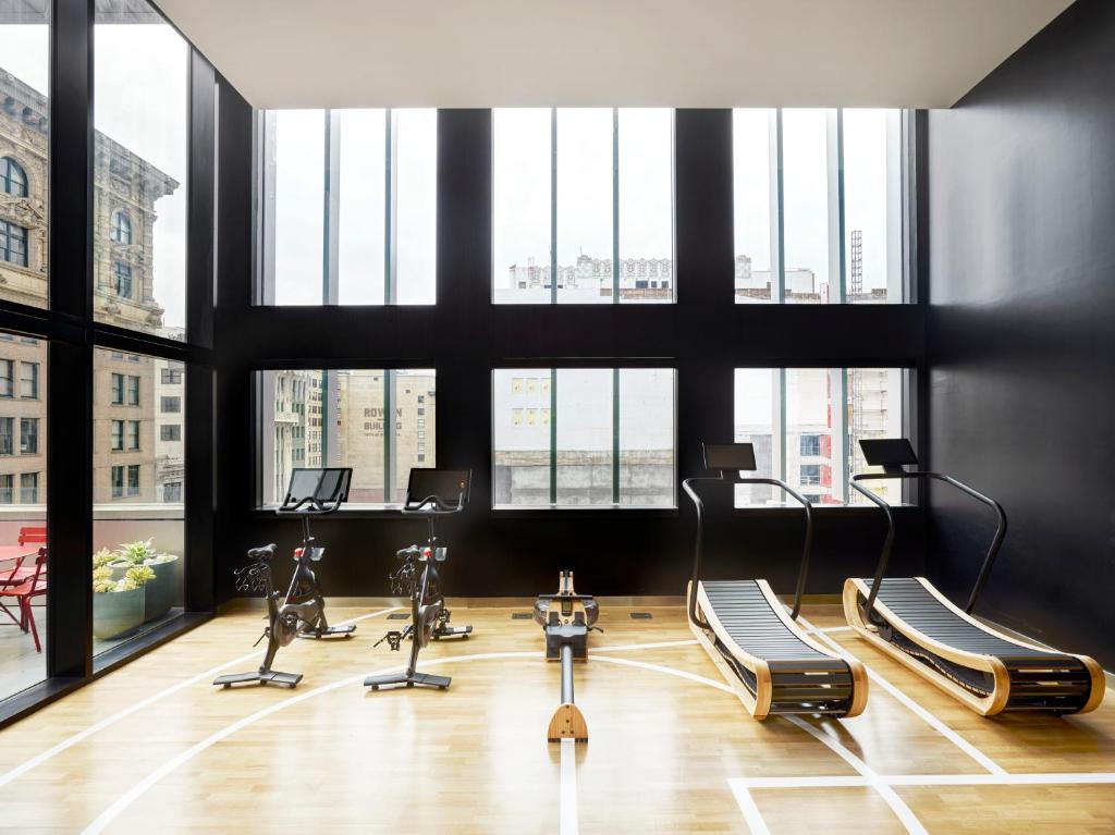 einen Fitnessraum mit einem Haufen Heimtrainer in einem Raum mit Fenstern in der Unterkunft citizenM Los Angeles Downtown in Los Angeles