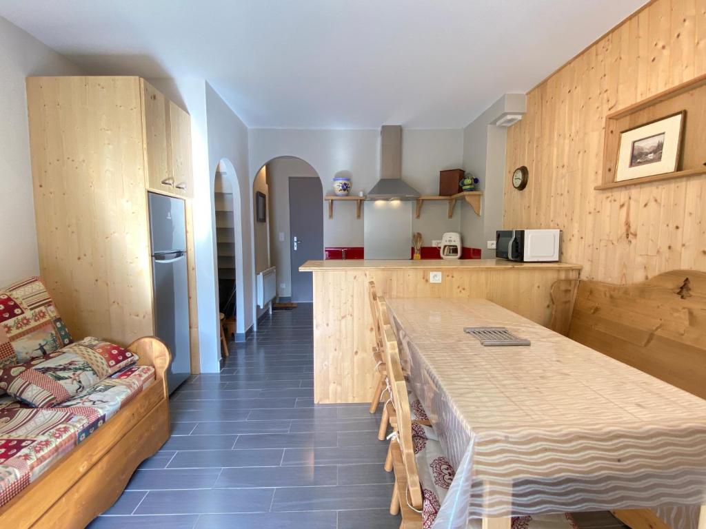 a kitchen with a table and a couch in a room at Joli chalet 60m2 proche du centre. parking. balcon in Cauterets