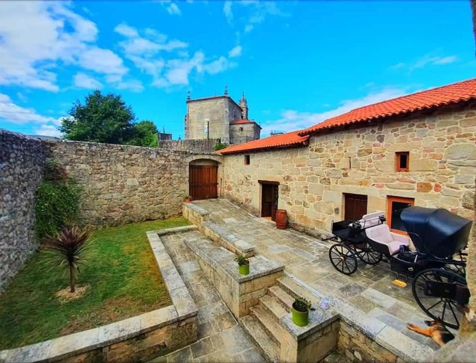 uma casa de pedra com um jardim e um cavalo estacionado no exterior em CASERIO RECTORAL DESTERIZ em Ourense