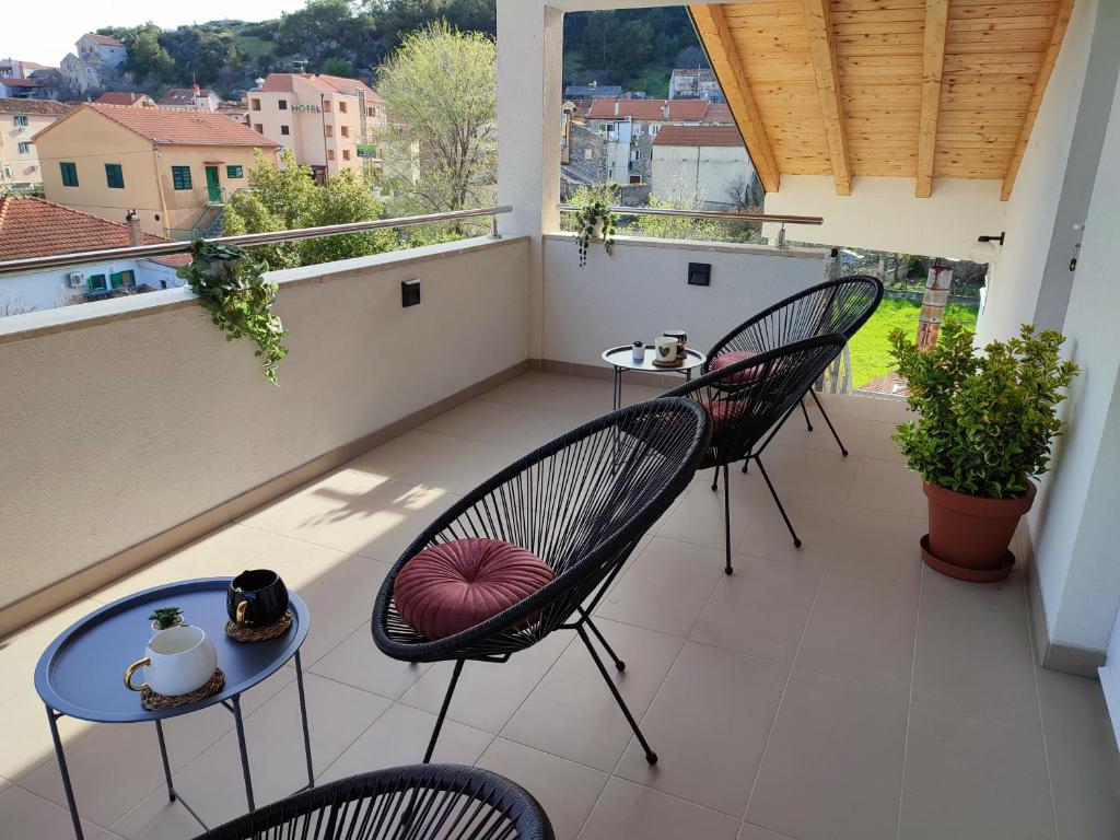 balkon z 2 krzesłami i stołem na balkonie w obiekcie Apartments Pulic w mieście Skradin