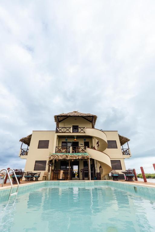 a resort with a swimming pool in front of a building at Lina Point Belize Overwater Resort in San Pedro