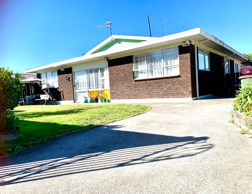 a brick house with a driveway in front of it at Rotorua City Center Holiday House in Rotorua