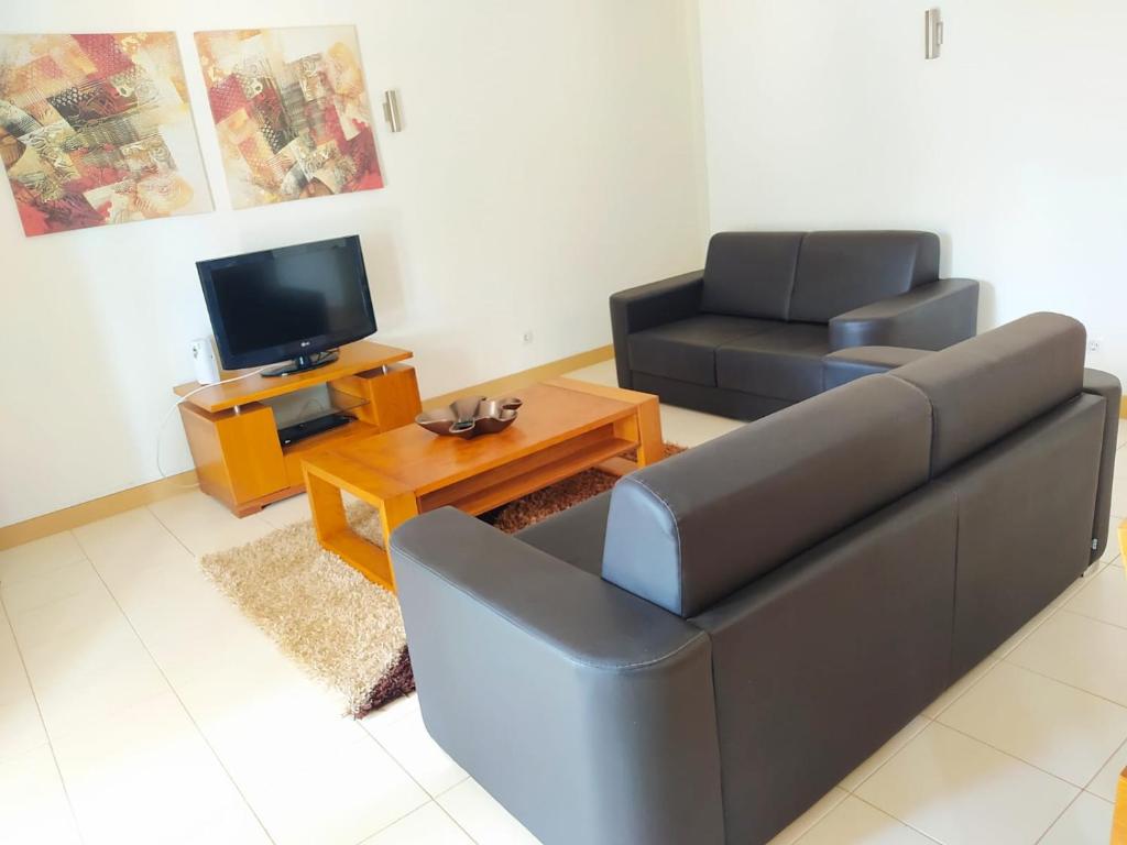 a living room with a couch and a television at Apartamento Privado Vila Verde in Santa Maria