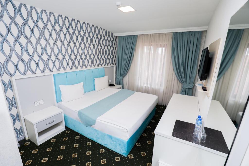 Habitación de hotel con cama y TV en Altus Hotel, en Baku