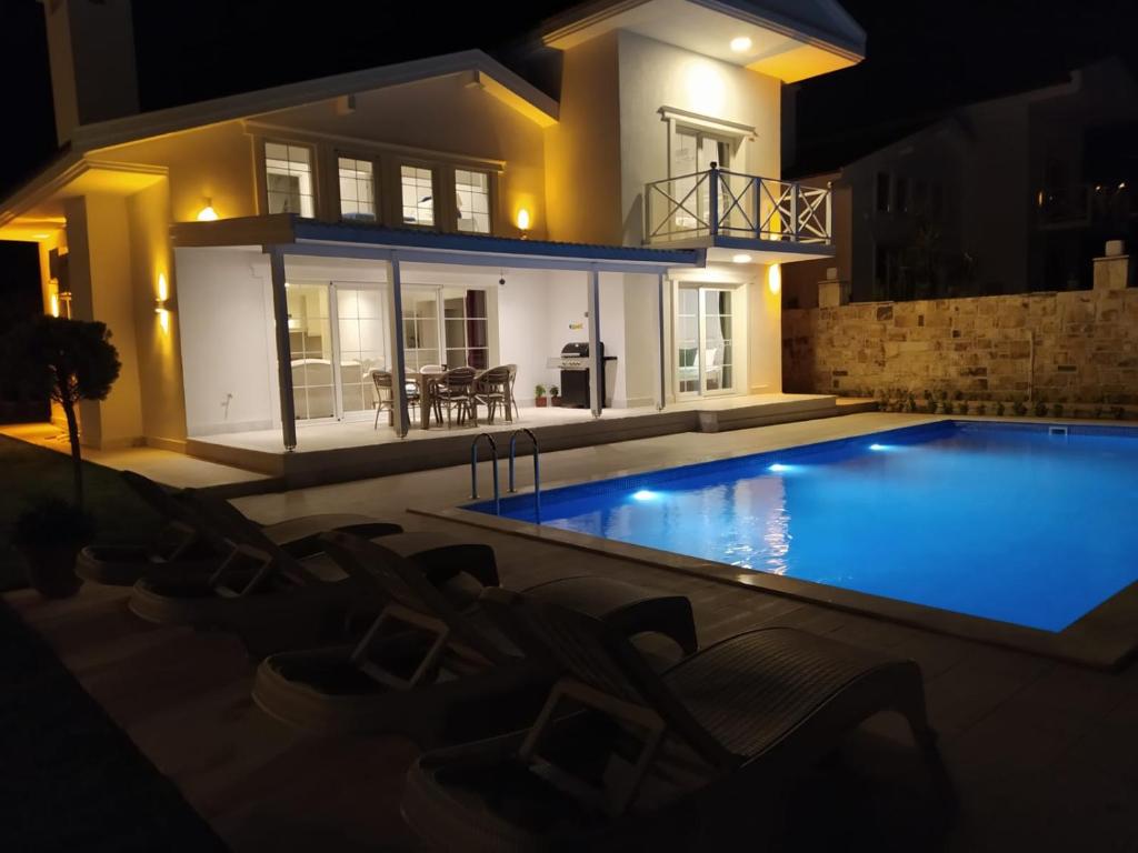 una piscina frente a una casa por la noche en Fantastic holiday house.. Toscana feeling by foça, en Foca