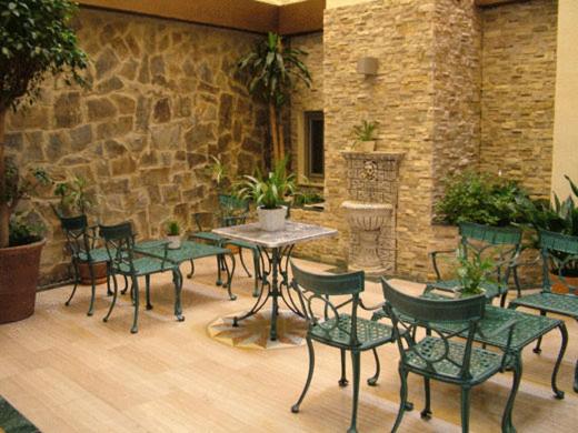 a patio with a table and chairs and a stone wall at Molino in Ronda