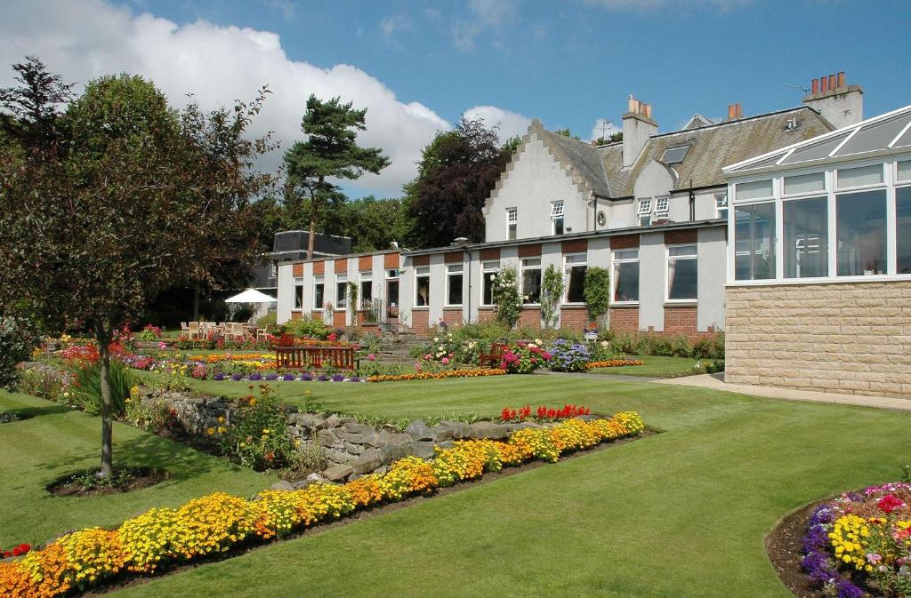 ダンファームリンにあるPitbauchlie House Hotel - Sure Hotel Collection by Best Westernの花の咲く建物の前の庭