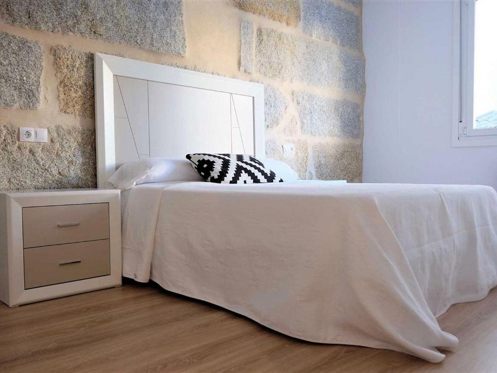 1 dormitorio con cama blanca y espejo en Delightful Apartment in Ourense overlooking the City, en Ourense