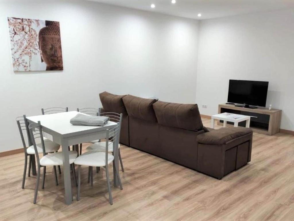 een woonkamer met een bank, een tafel en een televisie bij Elegant Apartment in Ourense with Private Terrace in Ourense