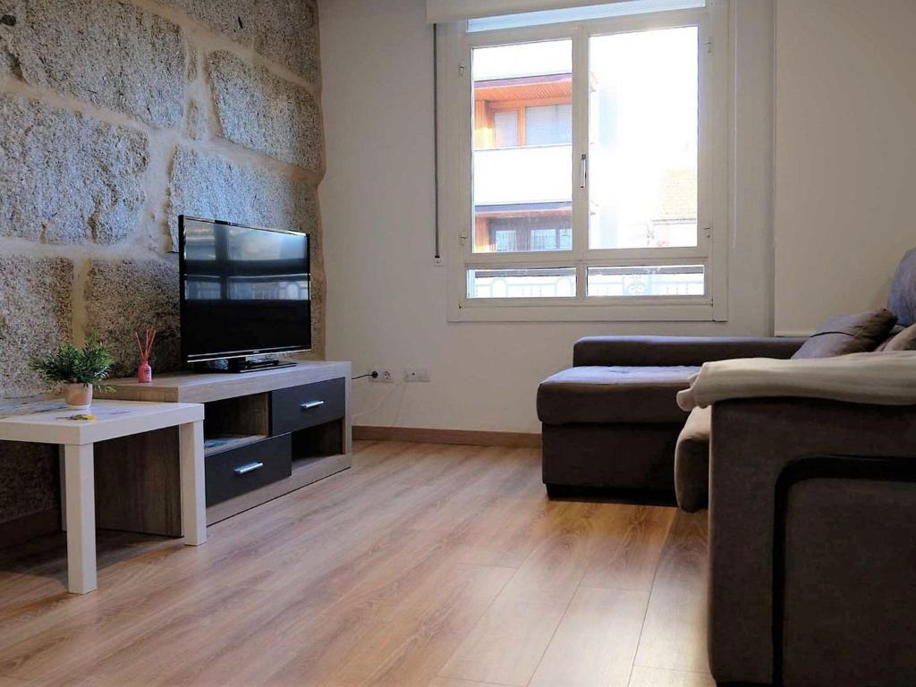 a living room with a couch and a flat screen tv at Apartment in Ourense near Thermal Baths in Ourense