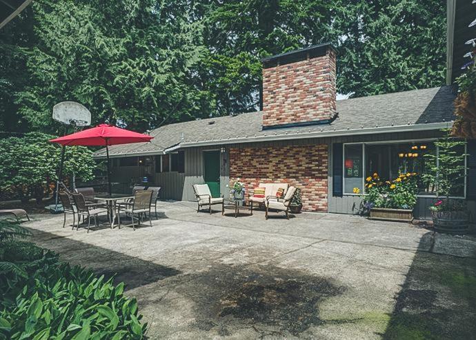 a patio with a table and chairs and an umbrella at Deer View Retreat in Welches