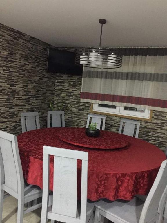 a dining room with a red table and white chairs at CasaMesquita in Cabeceiras de Basto