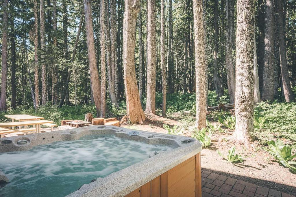 a hot tub in the middle of a forest at Chalet am Berg - Meredith Lodging in Government Camp