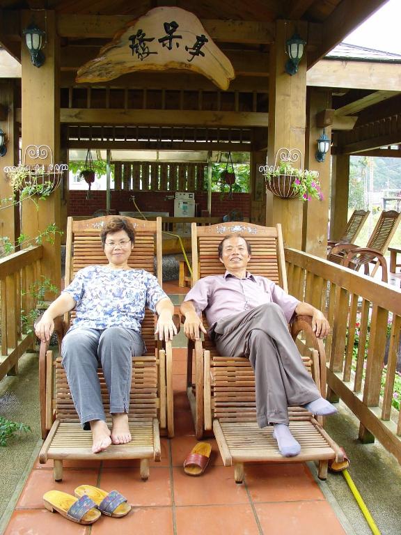 two women sitting in rocking chairs on a porch at Country Grange B&amp;B in Yuanshan