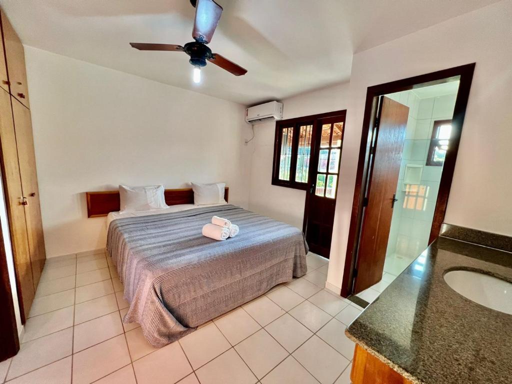 ein Schlafzimmer mit einem Bett und einem Deckenventilator in der Unterkunft Duplex Aconchegante Residencial Mont Sinai in Porto Seguro