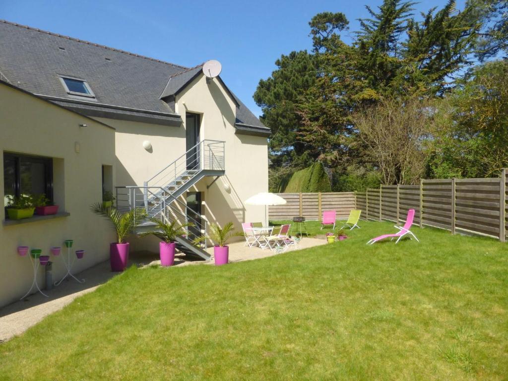 une cour avec des chaises roses et une maison dans l'établissement Apartment, Erquy, à Erquy