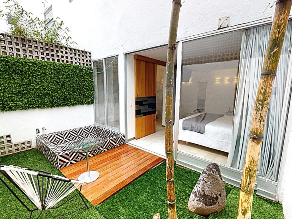 a glass house with a garden and a bedroom at Hotel CLARUM 101 in Guadalajara
