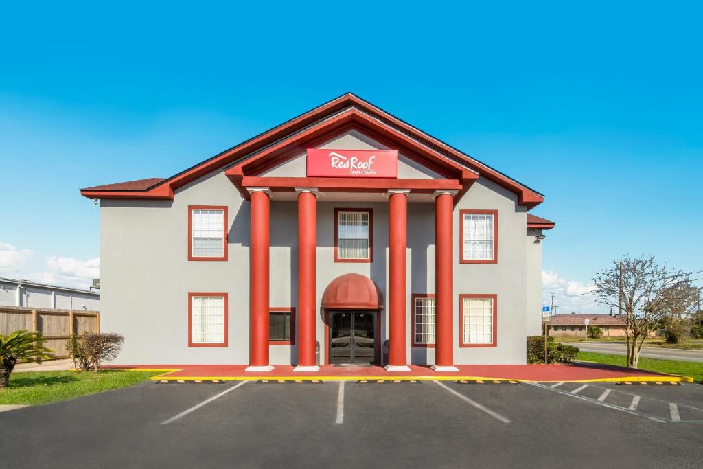 un hotel con un letrero rojo en un estacionamiento en Red Roof Inn & Suites Pensacola-NAS Corry, en Pensacola