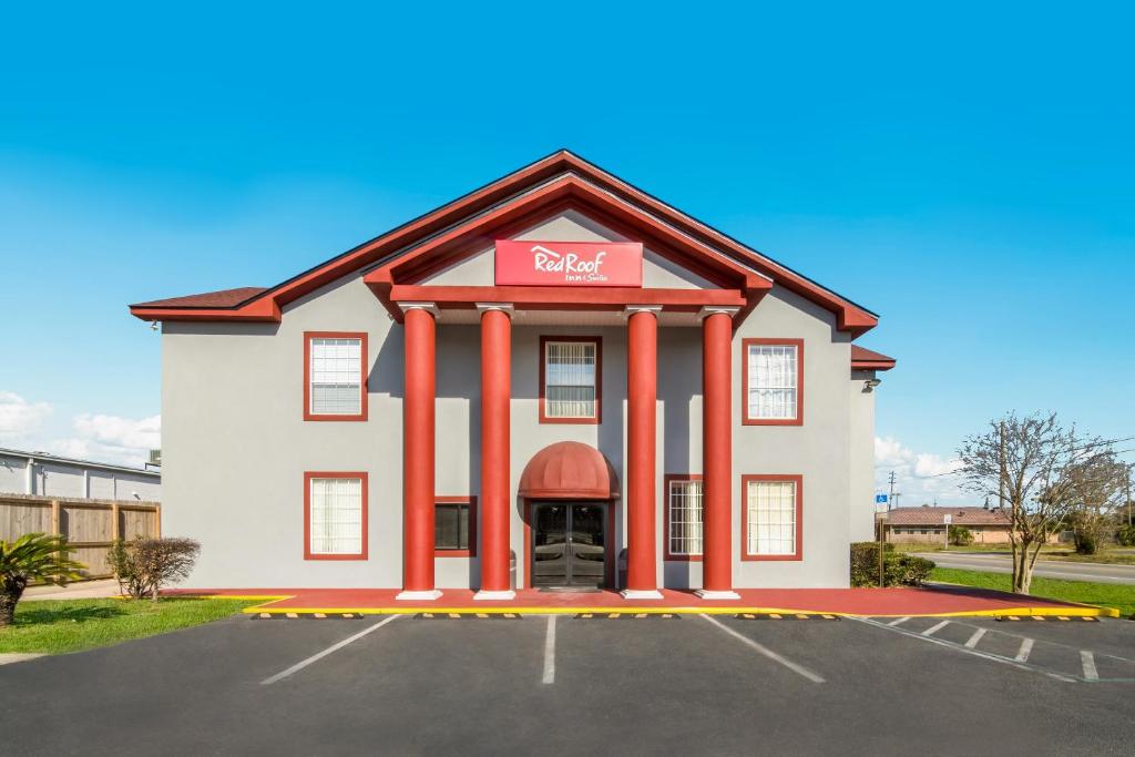 un hôtel avec un panneau rouge dans un parking dans l'établissement Red Roof Inn & Suites Pensacola-NAS Corry, à Pensacola