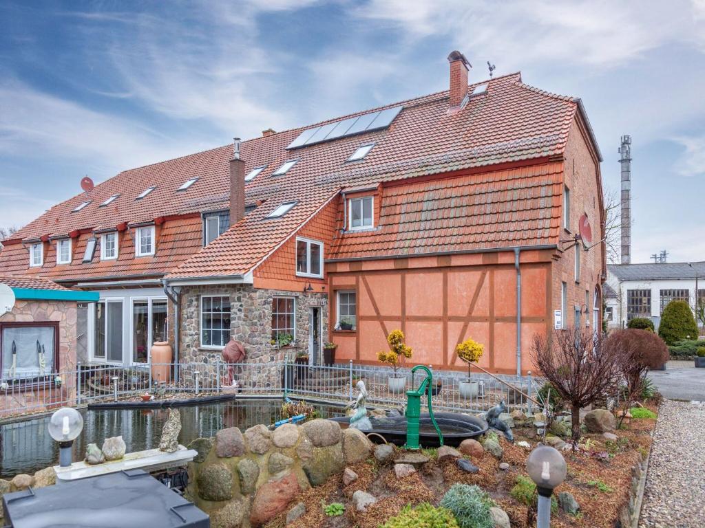 een huis met een vijver ervoor bij Budget Apartment in Grundshagen with garden seating in Klütz