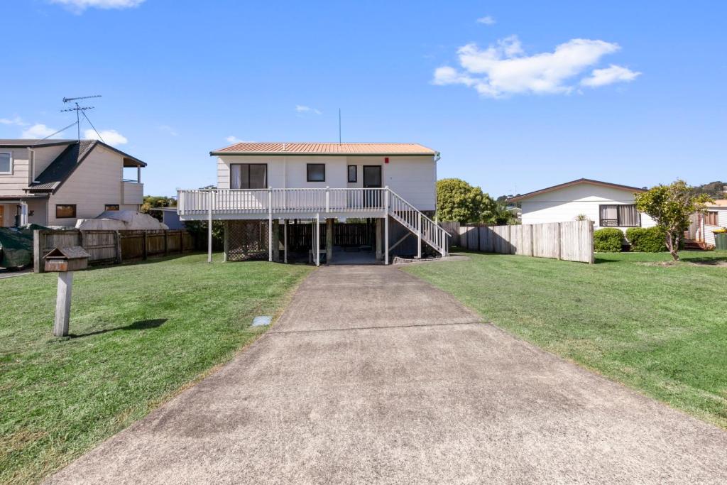 a house with a porch and a driveway at Snells Seaside Bach - Snells Beach Holiday Home in Snells Beach