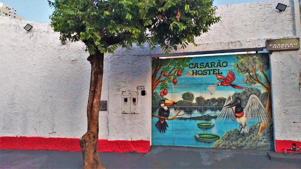 a mural on the side of a building with a tree at Casarão Hostel Cuiabá in Cuiabá