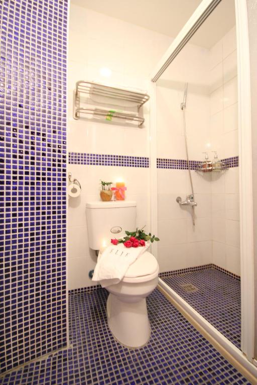 a bathroom with a toilet with flowers on the seat at Beautifl Sweet Warm B&amp;B in Hualien City