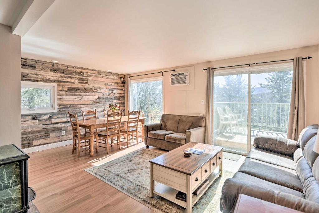 a living room with a couch and a table at Mountain Condo with Views Near Hiking and Biking! in Stowe
