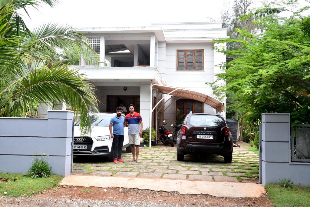 a group of people standing in front of a house at Kannur Beachway Homestay in Pāppinisseri