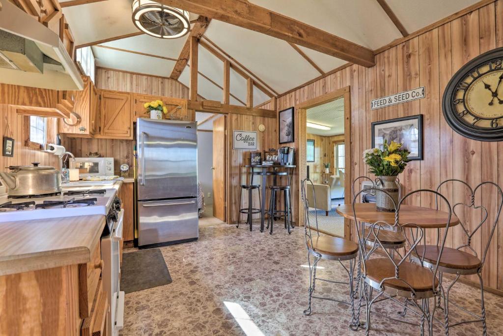 a kitchen with wooden walls and a large clock on the wall at Highland Haven Cabin on Working Cattle Farm! 