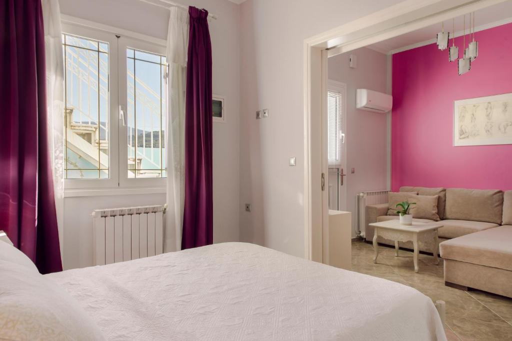 sypialnia z łóżkiem i salon z fioletowymi ścianami w obiekcie Casa di Mema w mieście Argostoli