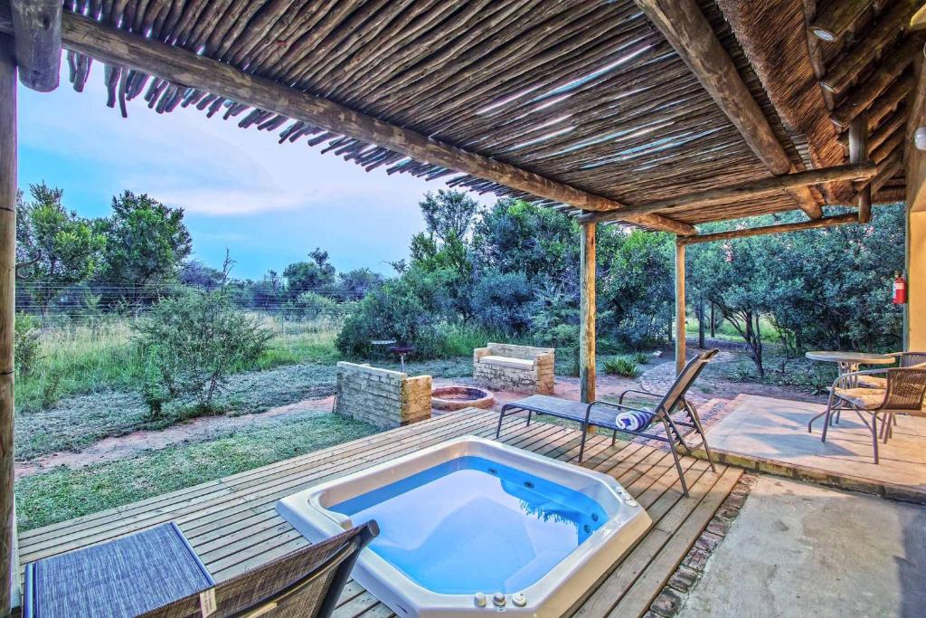an outdoor pool with a hot tub on a deck at LookOut Safari Lodge in Klipdrift