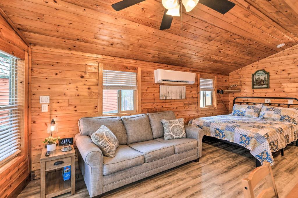 een woonkamer met een bank en een bed in een hut bij Beautiful New Bern Studio Cabin with Fire Pit! in New Bern