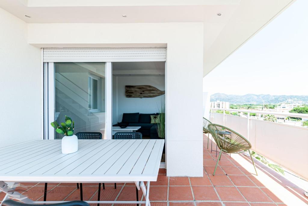 a balcony with a white table and a couch at Vista Roses Mar - Apartamento con piscina II in Roses