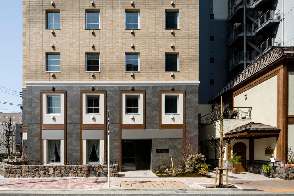 a large brick building with windows on a city street at Hotel Rilassare Tokyo in Tokyo