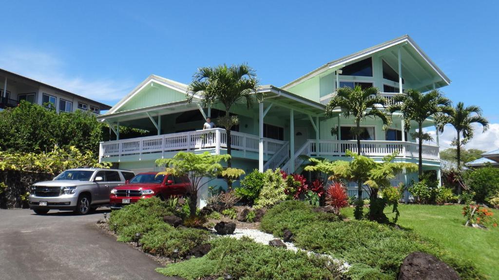 a green house with cars parked in front of it at GUEST HOUSE IN HILO in Hilo