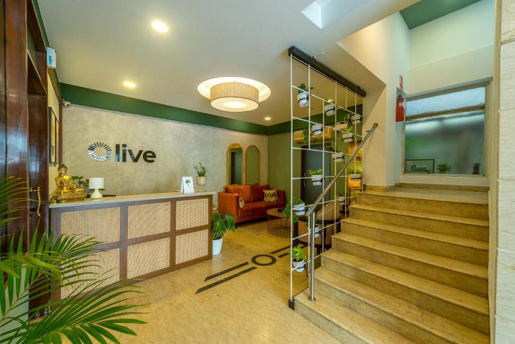 a lobby with stairs in a building with at Olive Rest House Road by Embassy Group in Bangalore