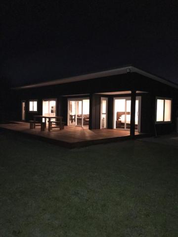 uma casa à noite com uma mesa de piquenique à frente em Dunray Cottage - Welcome to Havelock North em Hastings
