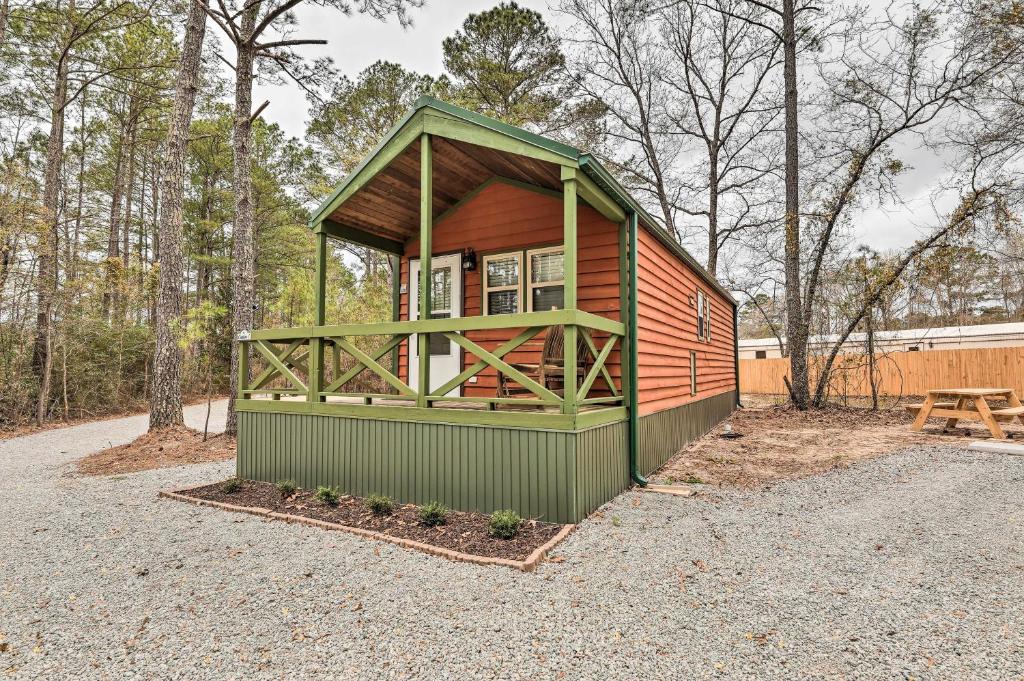 a small cabin in the woods with a bench at Charming New Bern Log Cabin - Pets Welcome! in New Bern
