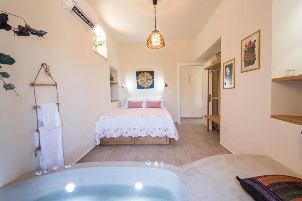 a bathroom with a tub and a bed in a room at Mandarinies Boutique Residence in Kalymnos