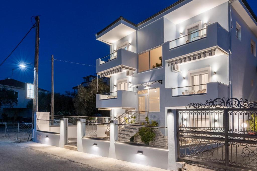 a white apartment building at night with lights at Ninemia Studios in Limenas