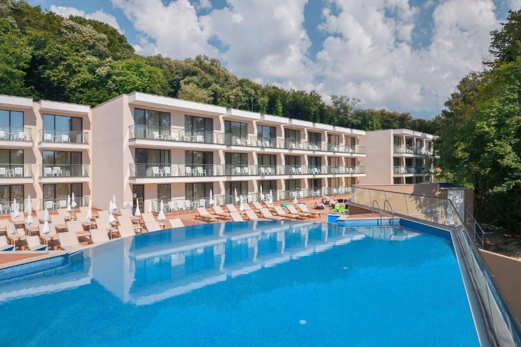 un hôtel avec une grande piscine et des chaises longues dans l'établissement GRIFID Hotel Foresta - All Inclusive & Free Parking - Adults Only, aux Sables d'or