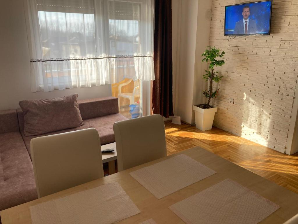 a living room with a couch and a table and chairs at Apartman Jana Apatin in Apatin