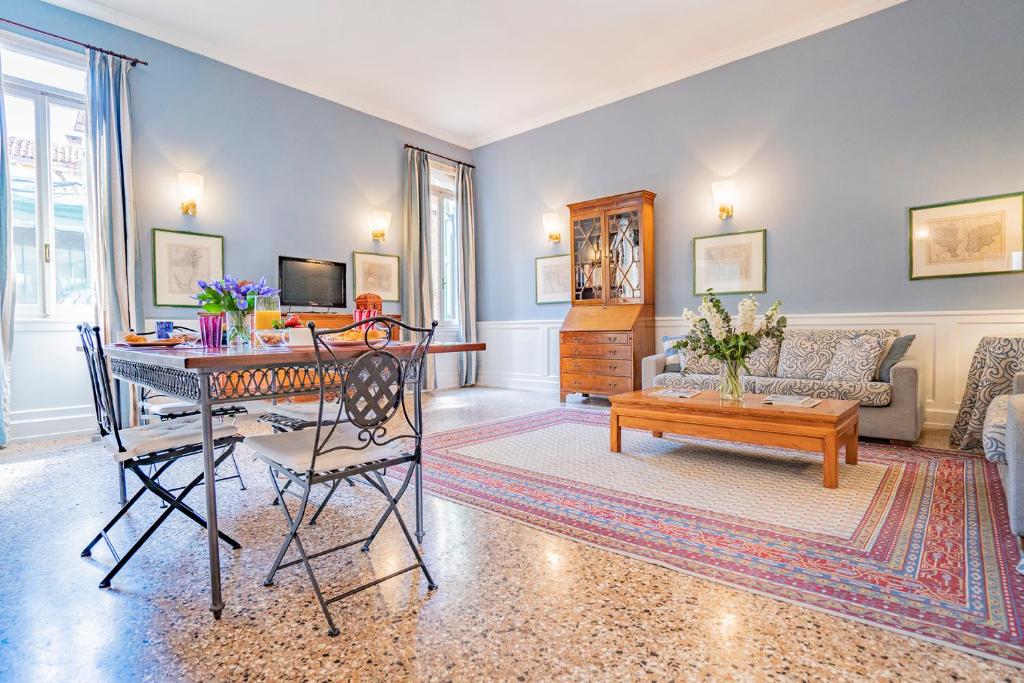 uma sala de estar com uma mesa e um sofá em Ca' Grassi 1 Venetian Apartment em Veneza